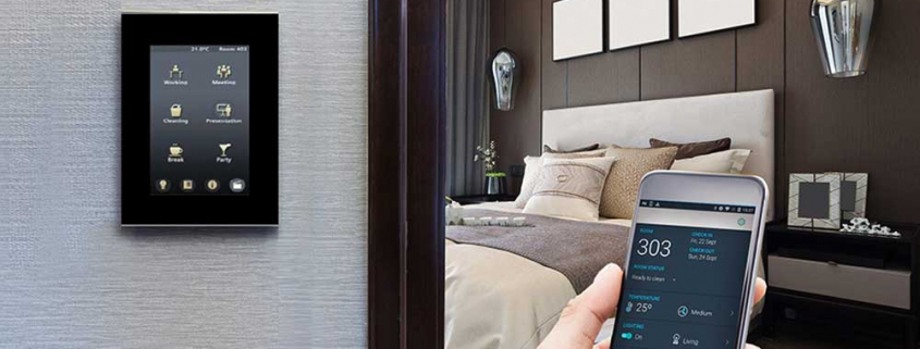 تصویری از اتاق در هتل هوشمند است که بر روی دیوار آن پنل لمسی قرار دارد.