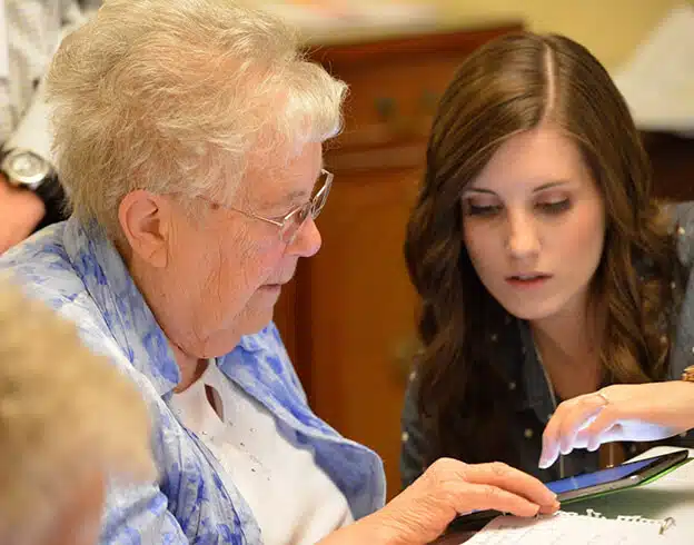یک دختر در حال آموزش کار با خانه هوشمند ویژه سالمندان به مادر سالخورده خود است