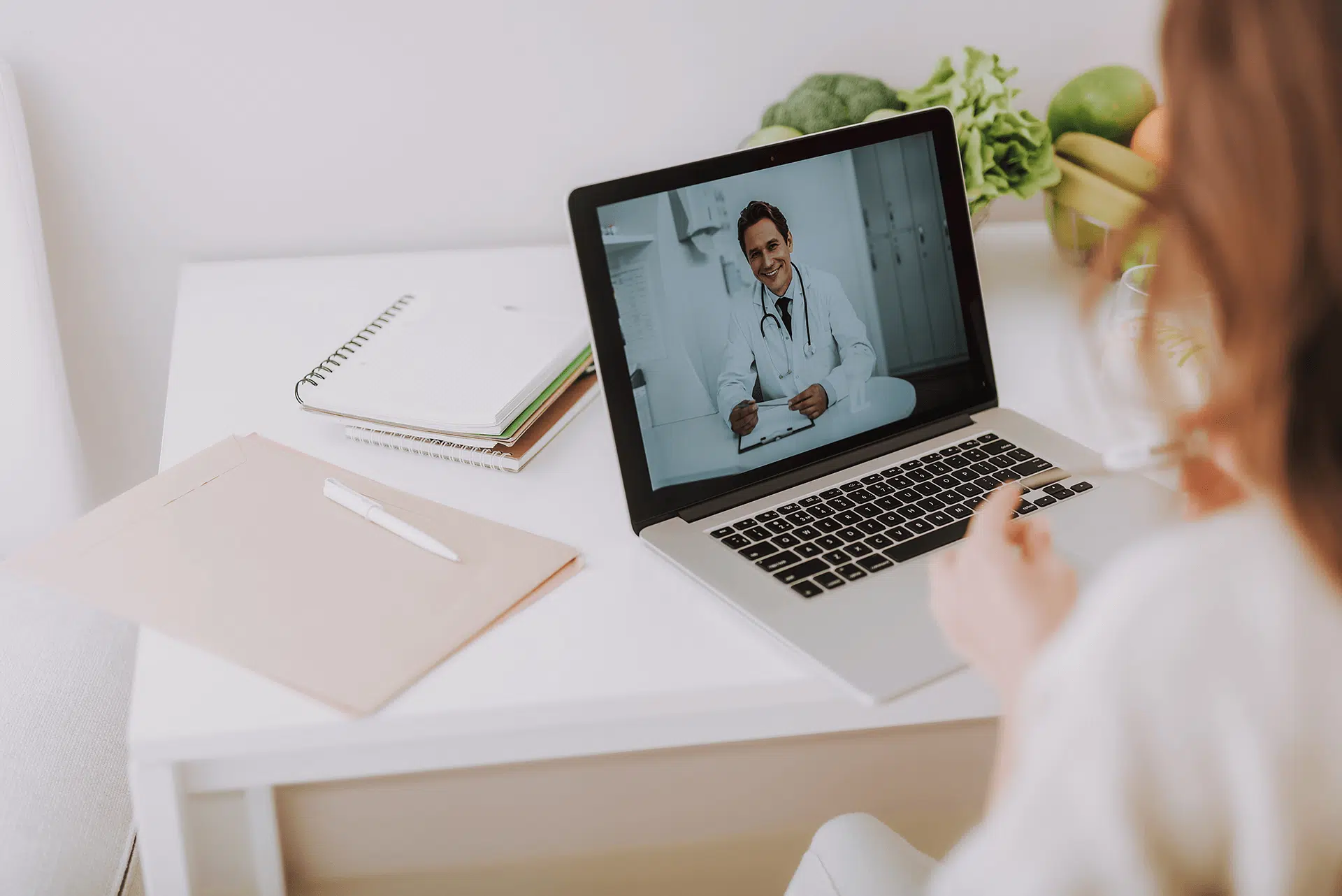 تصویری از ارتباط بین پزشک و بیمار از طریق لپ تاپ در مراکز درمانی هوشمند را نشان می دهد.